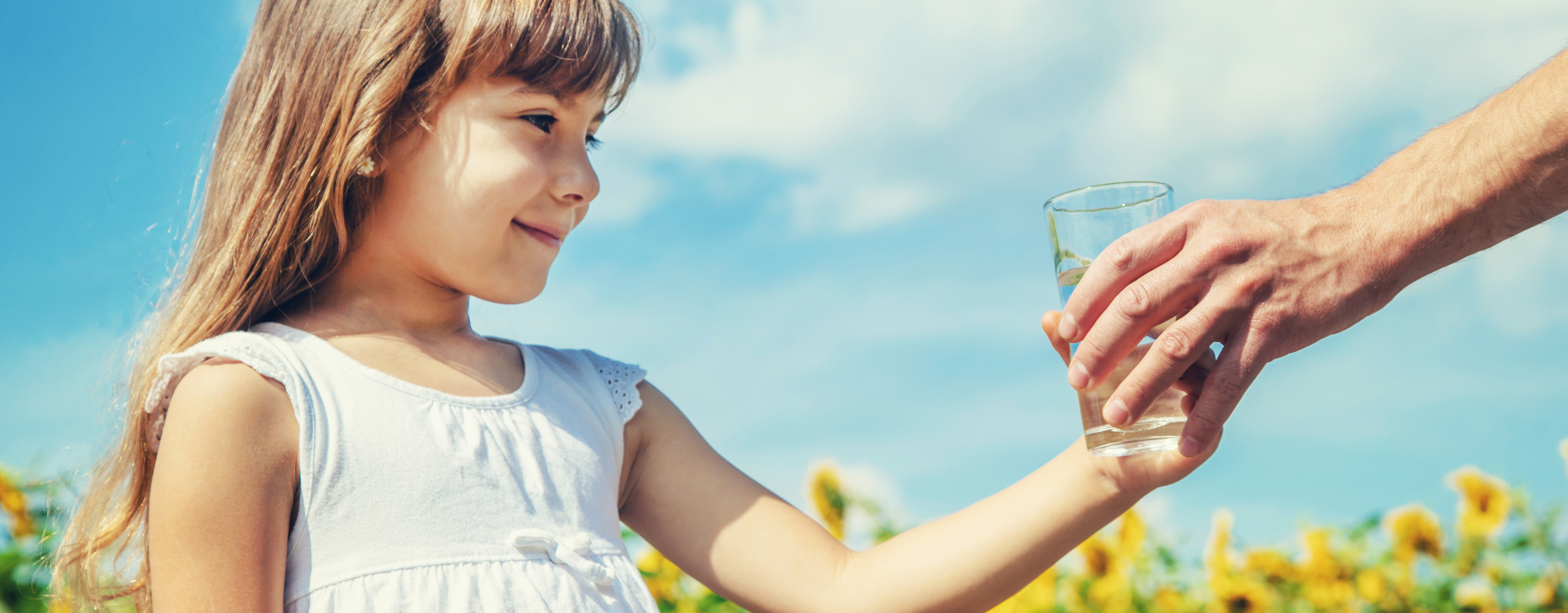 Child receiving a glass of clean, pure water