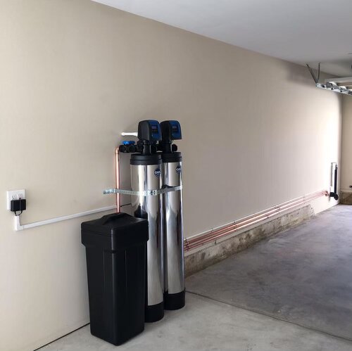 Whole house water treatment system with chrome tanks and copper piping in garage